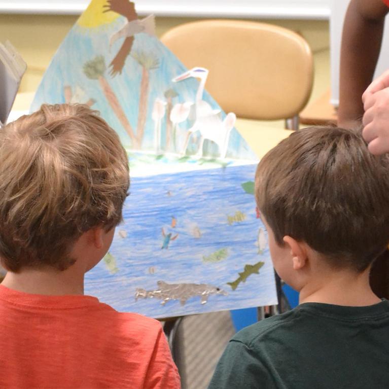 Lower School students look at their drawings at Chase Collegiate.